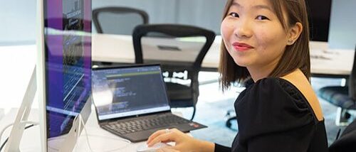 girl smiling at camera at computer
